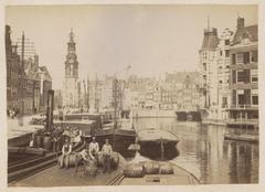 View of the Amstel river from Halvemaansbrug towards Muntplein in Amsterdam, featuring the tower of Hotel Rondeel after its 1883 expansion by Ed. Cuypers, with the Munttoren and the new Muntgebouw from 1887 in the background