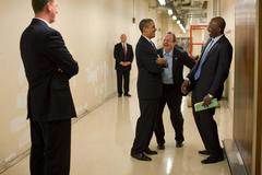President Barack Obama joking with Press Secretary Robert Gibbs and aide Reggie Love at a 2009 campaign reception
