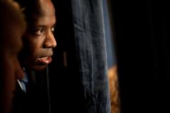 Personal aide Reggie Love peeking between the curtains at a political reception in Miami