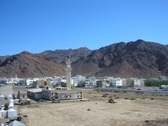 View of Mount Uhud with its rocky peak and expansive green surroundings under a clear blue sky