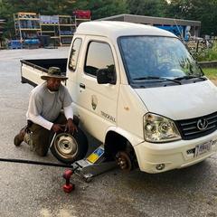 NPS employee Alphonso changing a tire next to a maintenance vehicle