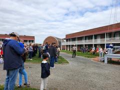 Group of visitors watching Fort McHenry Guard perform fife and drum music during Living History presentation