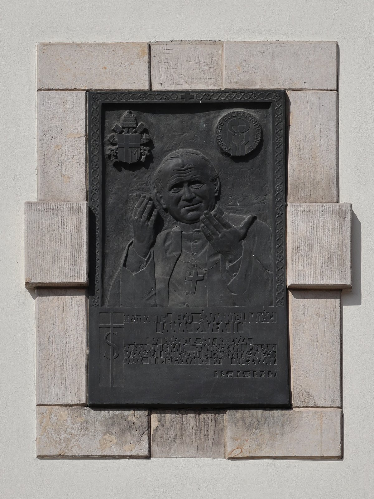 Memorial plaque of Pope John Paul II on the facade of the Holy Cross Basilica in Warsaw