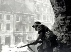 Insurgent observing Krakowskie Przedmieście Street from collapsed Holy Cross Church during Warsaw Uprising