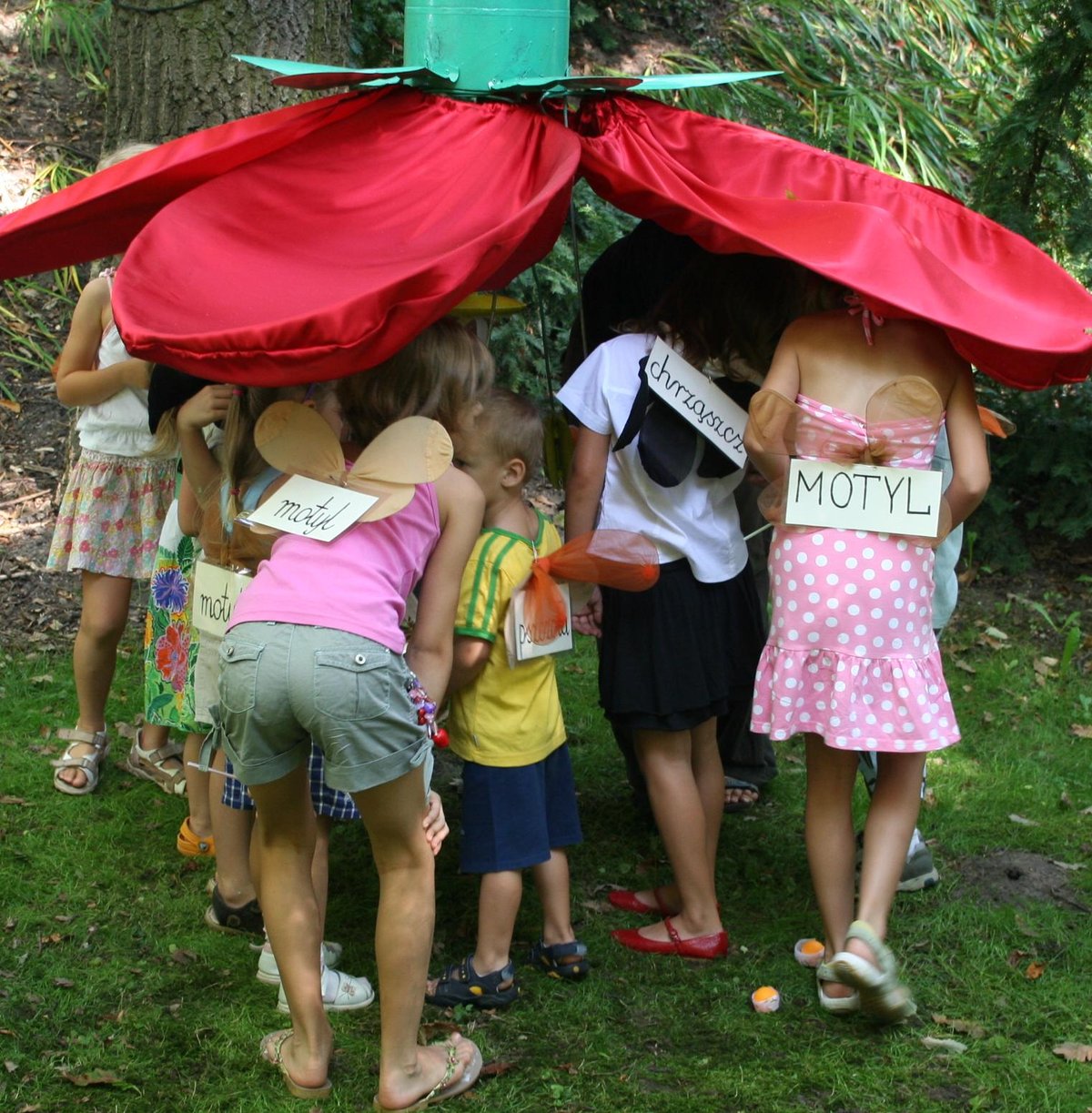 Children playing around large flower model in University of Warsaw Botanic Garden