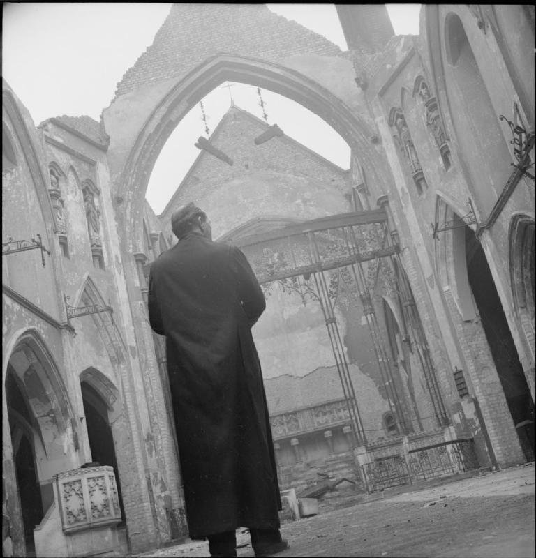 Bomb damage to St George's Cathedral in Southwark, London, 1942 with Father Frederick Dixon surveying the ruins