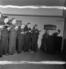 Worshippers singing hymns with piano accompaniment at Archbishop Amigo Hall in Southwark, 1942 after St George's Cathedral was bombed