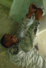 American airman repairs pipe under bathroom sink near Sultan Saqi Shrine in Iraq