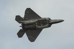 F-22 Raptor fighter jet performing high speed pass with bomb bay door open during Arctic Thunder Open House 2016