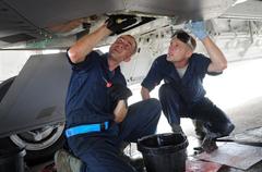 US Air Force crew chiefs performing maintenance on F-22 Raptor hydraulic pump