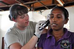 U.S. Air Force Senior Airman Ashley Cope conducting ear exam on East Timorese woman in clinic
