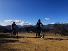 Mountain biking on a dirt trail in Topanga State Park with trees and hills