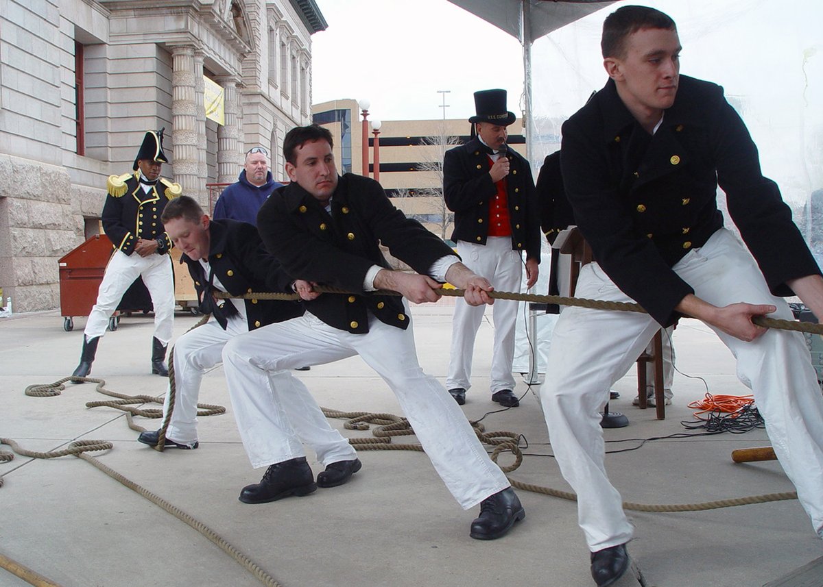 Three U.S. Navy seamen operate a 5,600-pound 1812-era Naval long gun during a cannon firing demonstration in Colorado Springs