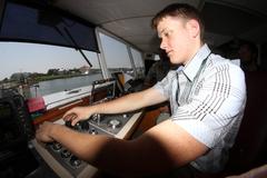 Corps dredge vessel Currituck operating at Rudee Inlet with Old Dominion University student in captain's chair