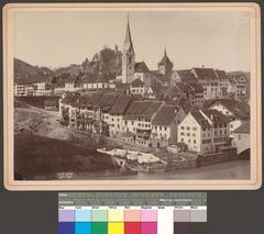 View of Baden town from Ennetbaden showing Maria Himmelfahrt Church, Stadtturm, Stein Ruin, part of the wooden bridge, and residential houses with laundry lines