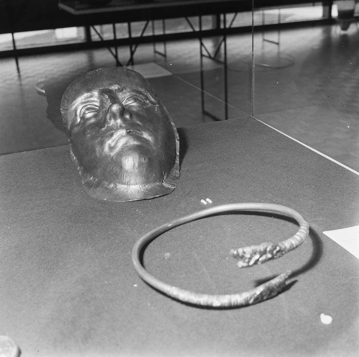 Black and white photo of a facial mask and neck ornament exhibited in the Soviet Union art treasures exhibition in the municipal museum, The Hague, 1966