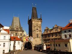 Charles Bridge in Prague during sunset with view of Vltava River and city skyline