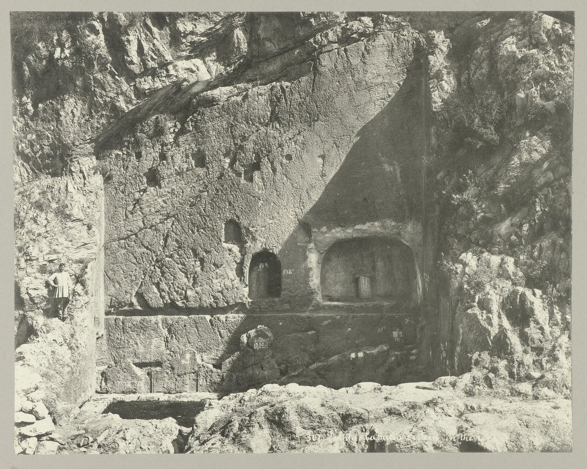 Historical photograph of the Castalian Spring at Delphi with inscriptions on the rock where pilgrims washed before consulting the oracle
