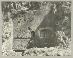 Historical photograph of the Castalian Spring at Delphi with inscriptions on the rock where pilgrims washed before consulting the oracle