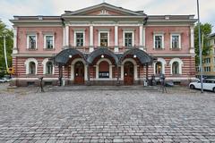 Alexander Theatre in Helsinki illuminated at night with colorful lights and modern city surroundings