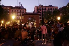 People celebrating Fiestas del Dos de Mayo in Malasaña with red and yellow flags