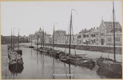 Historic view of Havenstraat harbor area in Scheveningen with early 20th century vehicles and ships