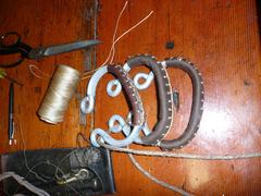 Metal sail hanks with handmade leather covers and rigging tools