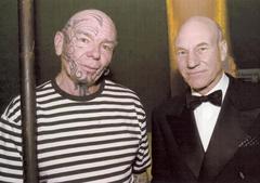 Park volunteer Tats stands with whaling harpoon next to actor Patrick Stewart during Moby Dick 150th anniversary event