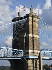 Closeup of Roebling Suspension Bridge Tower with gold plated Greek Cross finials and U.S. and Ohio flags