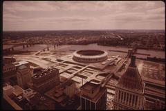 Riverfront Stadium on the Ohio River with towboat and barges near Fort Washington Way highway