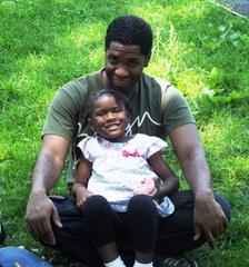 Father carrying child near Hamilton Grange National Memorial during Caribbean Day celebration