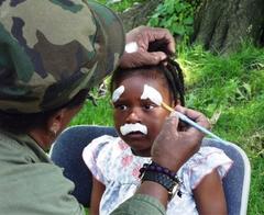 Child having face painted during Caribbean Day celebration