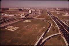 Junior high school football team playing on a field surrounded by freeways with Municipal Stadium in the left background