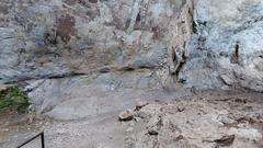 A clear space immediately below central rock paintings along a pathway