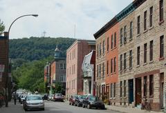 Plateau Mont-Royal neighborhood at Clark street and Duluth avenue in Montreal with Mount Royal and its cross in the background
