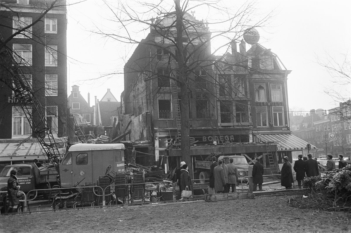 Demolition of building at corner Rembrandtsplein, one building completely torn down in black and white