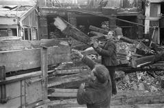 Demolition workers tearing down corner building at Rembrandtsplein in black and white on January 10, 1969