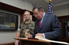 U.S. Navy Adm. Eric T. Olson observing Secretary of Defense Leon E. Panetta signing guest book at USSOCOM headquarters