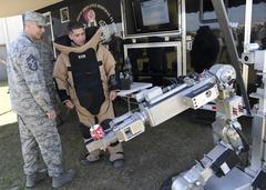 Chief Master Sgt. Todd Petzel listens to Senior Airman Jordan Oswald explain F6A remote ordnance neutralization system at MacDill Air Force Base