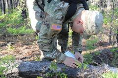 U.S. Army Reserve Staff Sgt. plotting grid coordinates on map during 335th Signal Command 2016 Best Warrior Competition
