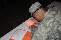 U.S. Army Reserve Staff Sgt. plotting grid coordinates on map during night land navigation at 335th Signal Command's 2016 Best Warrior Competition