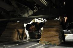 U.S. Air Force personnel loading a U.S. Army tactical vehicle onto a C-17 Globemaster III for Haiti earthquake relief