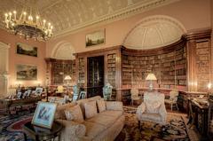 Interior of Harewood House main library with ornate ceiling, large chandelier, and wooden bookshelves filled with books