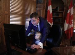 Andrew Scheer working in his office with assistance in 2018