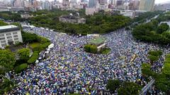 623 protest march with people holding banners and flags in Chosei