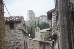 Panoramic city view of Assisi, Italy with historic buildings and surrounding hills under clear blue sky