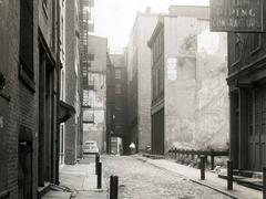 1950 black and white photo of narrow brick alley courtyard