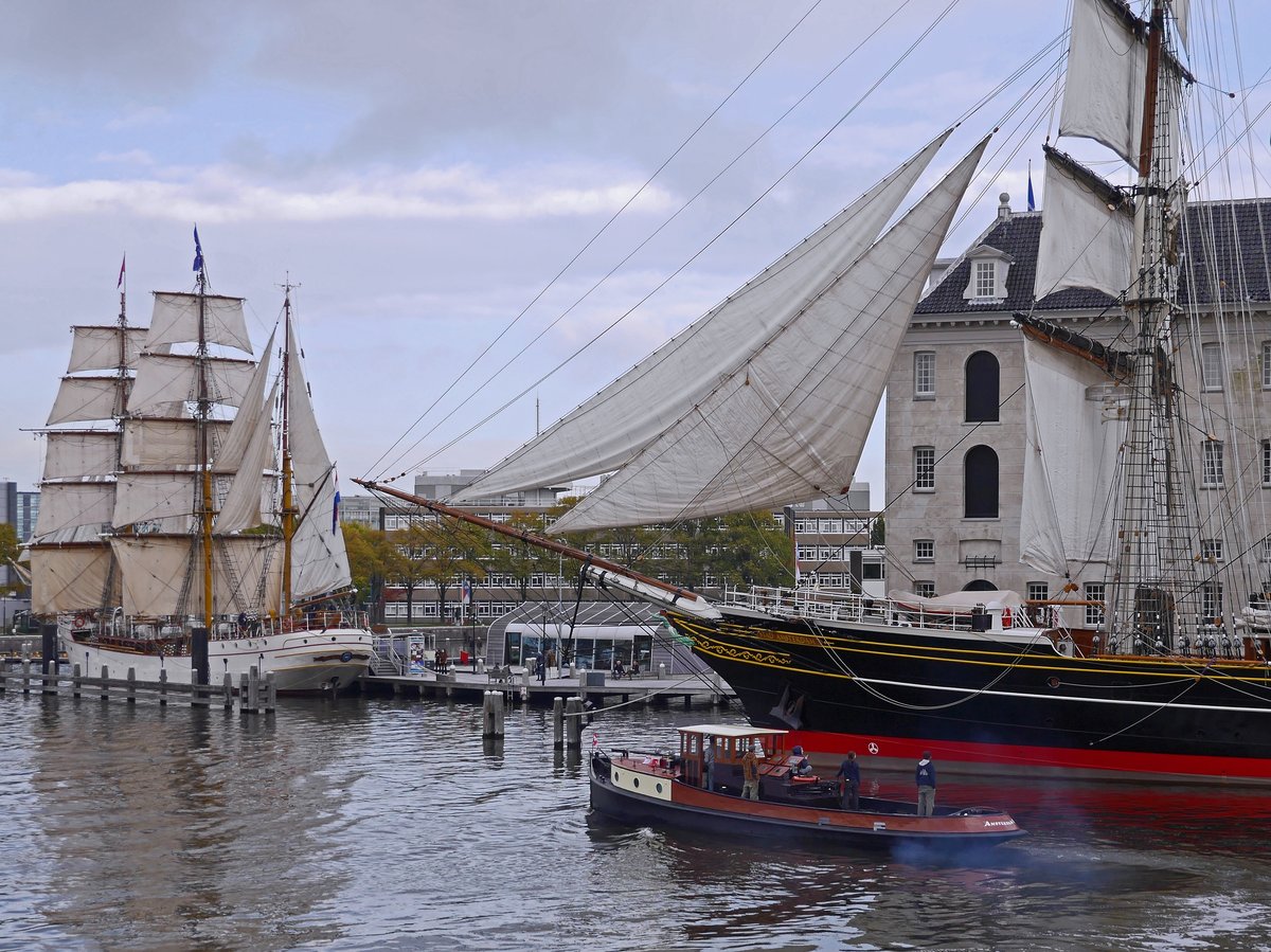 Sailing ships docked in the harbor water of Oosterdok in Amsterdam city, Netherlands