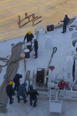 U.S. Navy Sailors and civil service mariners heaving lines aboard hospital ship USNS Comfort at Naval Station Norfolk