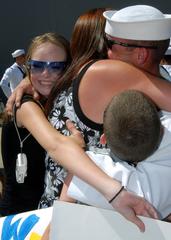 Sailor hugging family during USS Cole's return to Naval Station Norfolk after six-month deployment
